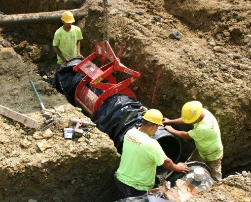 Wright Setting Wrapped Pipe in Trench