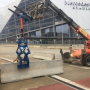 setting pedestrian control wall at Mercedes stadium using a Kenco Barrier Lift rigged to a Forklift Adapter