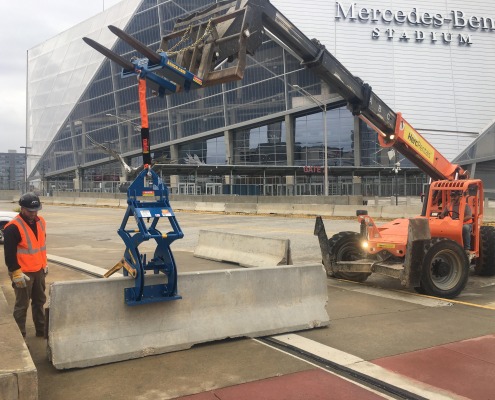setting pedestrian control wall at Mercedes stadium using a Kenco Barrier Lift rigged to a Forklift Adapter