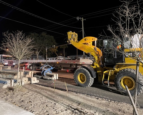 Kiewit Construction using a wheel loader with jib boom to set Florida Low Profile wall in place on roadway at night