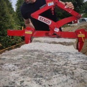 Man assuring stones are placed together closely in an outdoor granite wall installation project.