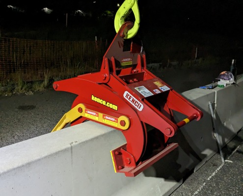 red clamp sitting on jersey barrier wall at night
