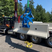 blue barrier wall clamp unloading truck with crane