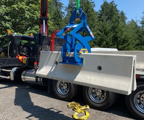 blue barrier wall clamp unloading truck with crane