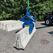 blue barrier clamp picking up concrete jersey wall