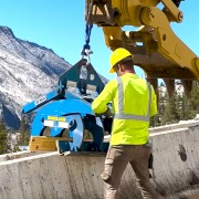 construction worker with blue barrier lift tool on concrete barrier in Yosemite