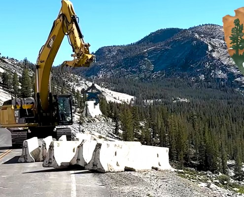 Kenco Barrier Lift picking up concrete jersey barricades in Yellowstone National Park with a CAT excavator