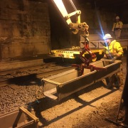 kenco lifting attachment being used to lift up split box concrete culvert in a mine with working guiding it into place