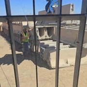 view from machine operator through safety fence moving barrier wall at precast site