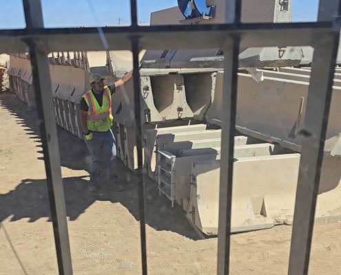 view from machine operator through safety fence moving barrier wall at precast site