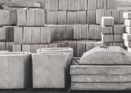 A storage unit full of various different shapes of concrete blocks, from slabs and blocks to other unique shapes.