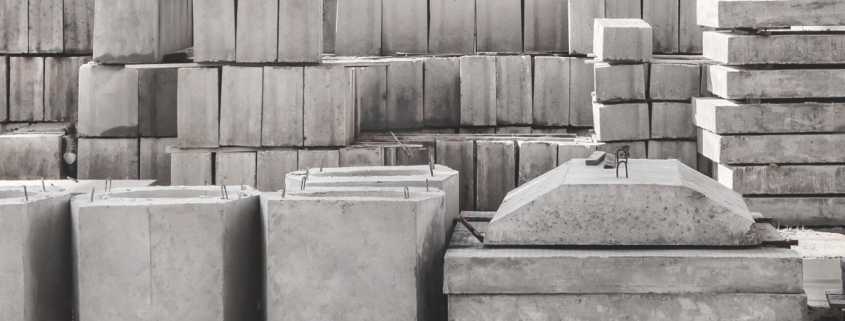 A storage unit full of various different shapes of concrete blocks, from slabs and blocks to other unique shapes.