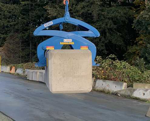 large format concrete block being picked up with a kenco scissor lifting clamp