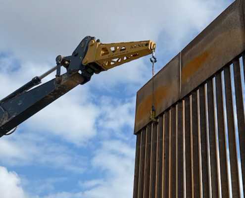 border wall panels being installed in Texas at the Mexico border with a jib boom attachment