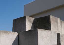 Large concrete blocks stacked on top of one another in a pile. Some blocks have metal handles in them.