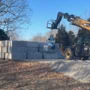 telehandler using material handler clamp for waste block install