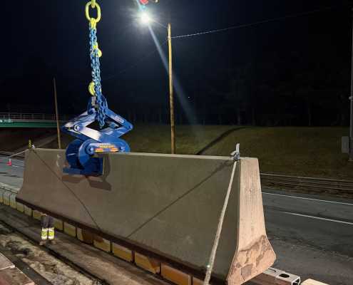 roadway construction at night setting barrier wall