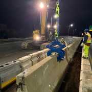 excavator on night project moving barrier wall