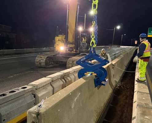 excavator on night project moving barrier wall