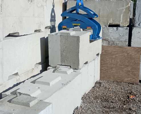 large waste block in front of stacked block picked up with kenco barrier lifter