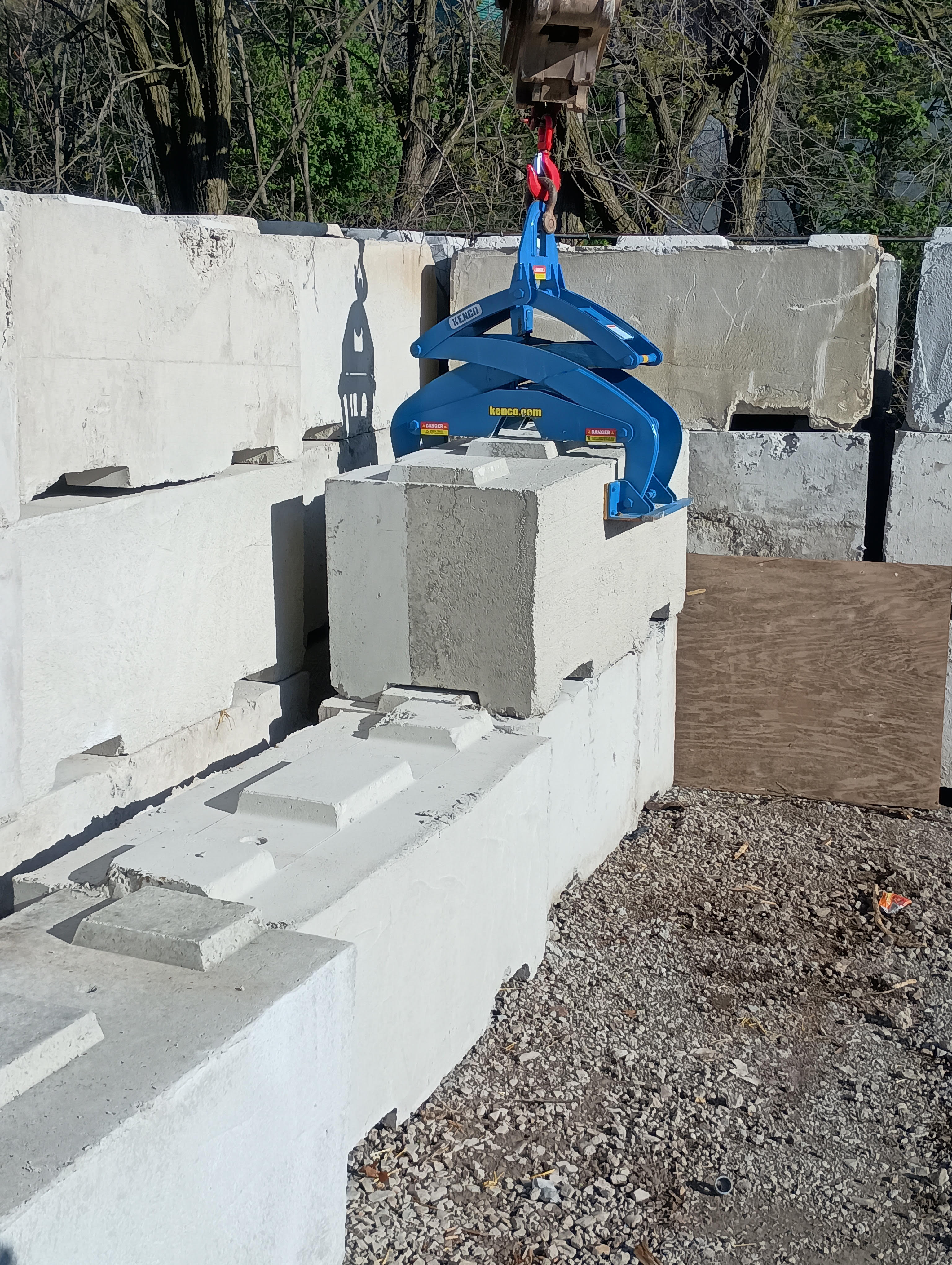 large waste block in front of stacked block picked up with kenco barrier lifter