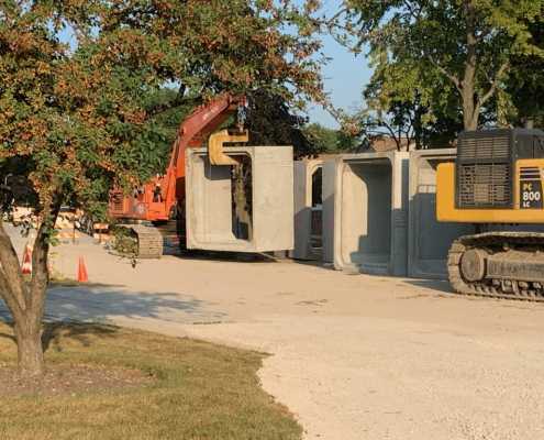 mid size excavator setting large box culverts with a yello pipe hook device