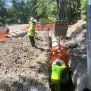 construction crew setting concrete pipe into trench using kenco pipe lifting tongs